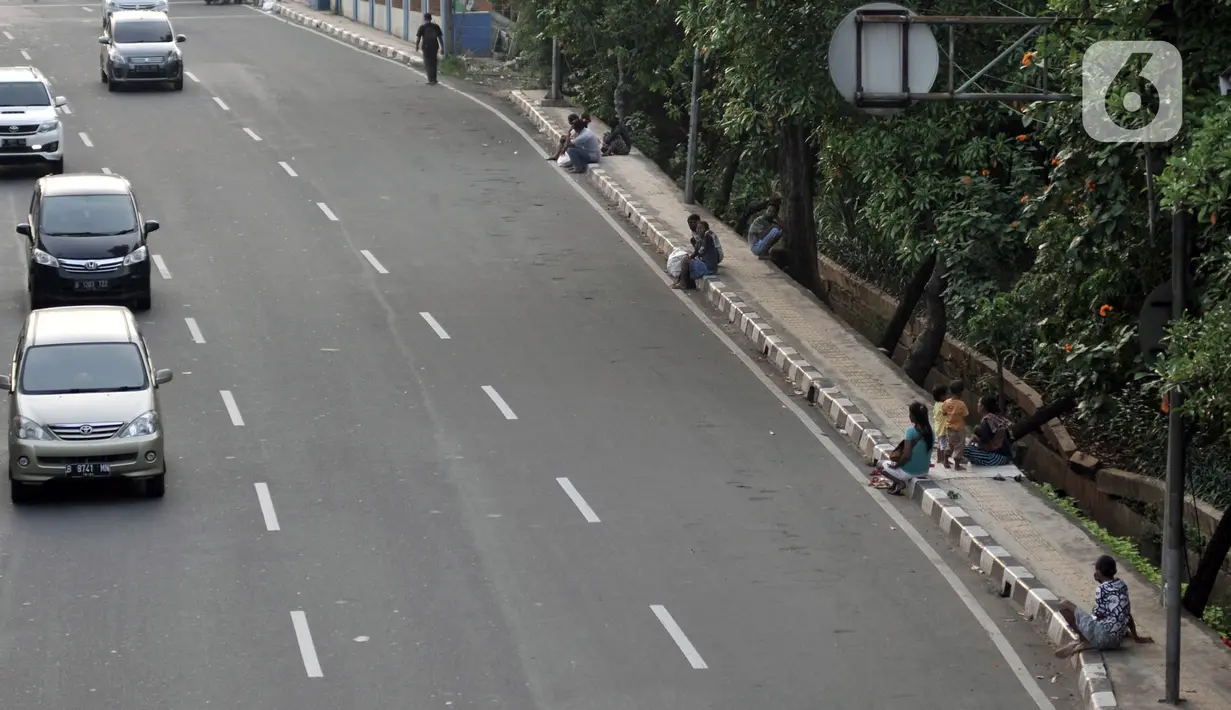 Penyandang Masalah Kesejahteraan Sosial (PMKS) menunggu warga memberikan sedekah di pinggir jalan, Jakarta, Rabu (13/5/2020). Sejumlah PMKS menantikan sedekah berupa uang, makanan, hingga sembako dari pengendara yang melintas. (merdeka.com/Iqbal S. Nugroho)