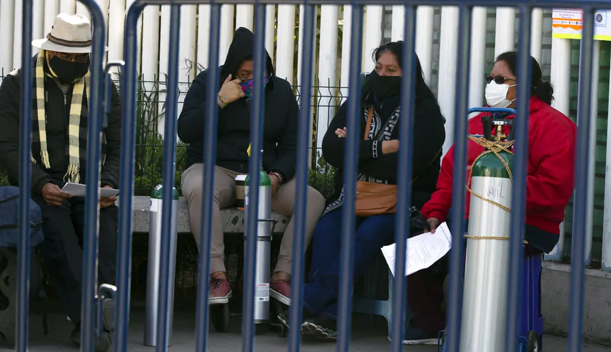 Orang-orang menunggu untuk mengisi ulang tangki oksigen bagi kerabat mereka yang menderita COVID-19 di Distrik Iztapalapa, Mexico City, Meksiko, Selasa (26/1/2021). Mexico City menawarkan isi ulang oksigen gratis untuk pasien COVID-19. (AP Photo/Marco Ugarte)