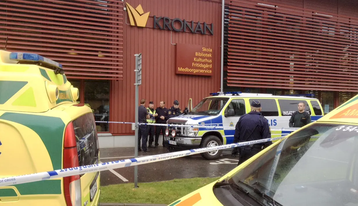 Petugas memasang garis polisi di sekolah Kronan di Trollhattan, Swedia barat, Kamis (22/10). Seorang pria bertopeng dan bersenjatakan pedang menyerang sekolah tersebut dan menewaskan satu murid dan satu guru. (REUTERS/Stig Hedstrom/TT News Agency)