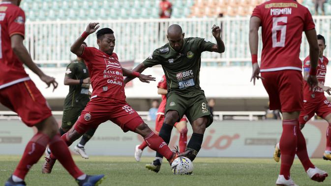 Striker PS Tira Persikabo, Loris Arnaud, berebut bola dengan pemain Persija Jakarta pada laga Shopee Liga 1 di Stadion Pakansari, Bogor, Selasa (16/7). Tira menang 5-3 atas Persija. (Bola.com/Yoppy Renato)