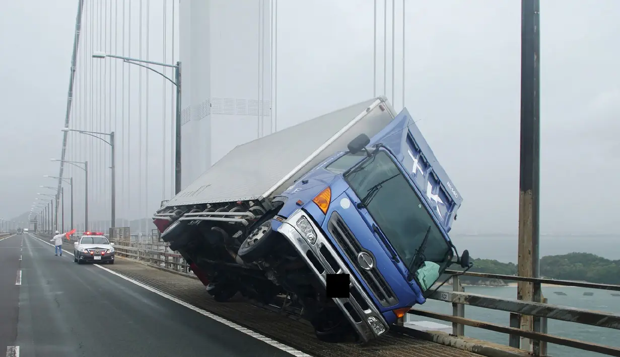 Sebuah truk tergelincir akibat angin topan jebi di jembatan Seto Ohashi di Sakade, Prefektur Kagawa di pulau Shikoku Jepang, (4/9). Topan ini juga mengakibatkan tanah longsor di berbagai tempat. (AFP Photo/Jiji Press)