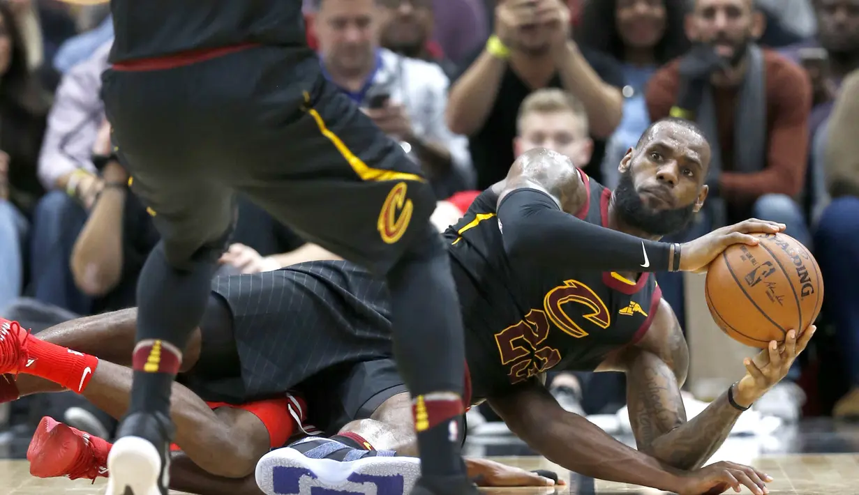 Pebasket Cleveland Cavaliers, LeBron James, terjatuh saat berebut bola dengan pebasket Chicago Bulls pada laga NBA di United Center, Selasa (5/12/2017). Cleveland Cavaliers menang 113-91 atas Chicago Bulls. (AP/Charles Rex Arbogast)