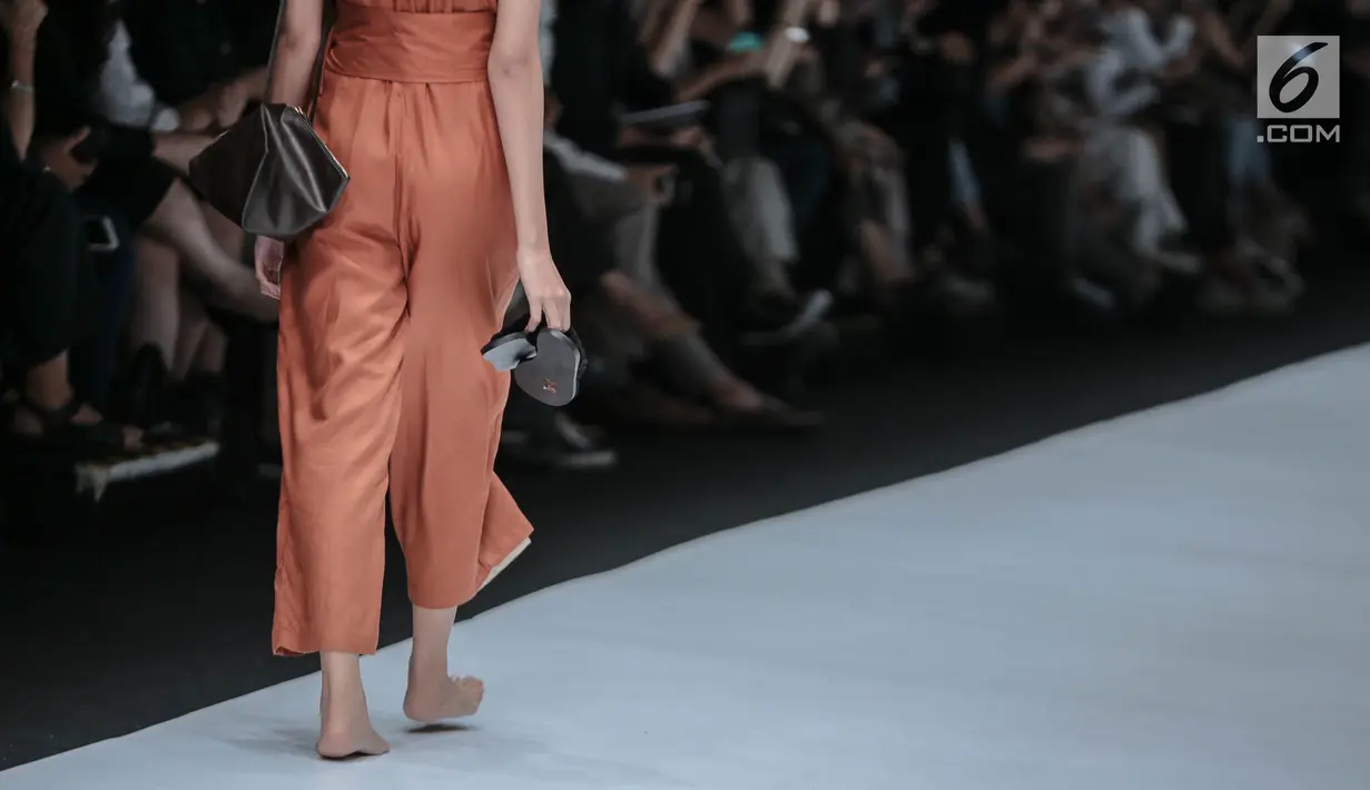 Model berjalan di catwalk mengenakan busana persembahan "COTTONINK" pada Jakarta Fashion Week 2019 di Senayan City, Rabu (24/10/2018). Pada peragaan busana itu "COTTONINK" mempersembahkan sejumlah rancangan dari beberapa artis (Liputan6.com/Faizal Fanani)