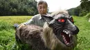 Chikao Umezawa, Ketua Asosiasi Koperasi Pertanian JA Kisarazu-shi, menunjukkan robot Super Monster Wolf di Kisarazu, prefektur Chiba, Jepang, 25 Agustus 2017. Robot serigala ini berhasil dikembangkan oleh Hokkaido Ohta Seiki. (Toru YAMANAKA/AFP)