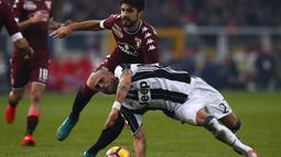 Gelandang Juventus, Stefano Sturaro, terjatuh saat berusaha melewati bek Torino, Luca Rossettini dalam laga pekan ke-16 Serie A 2016-2017 di Stadion Olimpico Grande Torino, Minggu (11/12/2016). (AFP/Marco Bertorello)