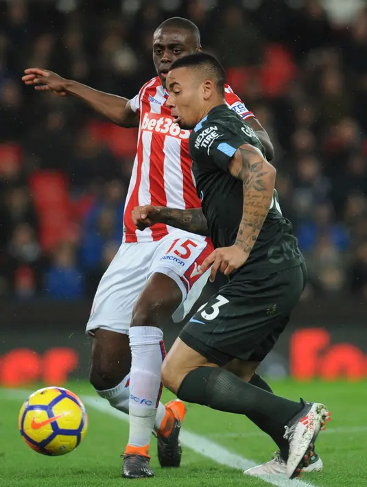 Pemain Manchester City, Gabriel Jesus berebut bola dengan pemain Stoke City, Bruno Martins Indi pada pertandingan pekan ke-30 Premier League di bet365 Stadium, Selasa (13/3). Manchester City sukses menaklukkan Stoke City dengan skor 2-0. (AP/Rui Vieira)
