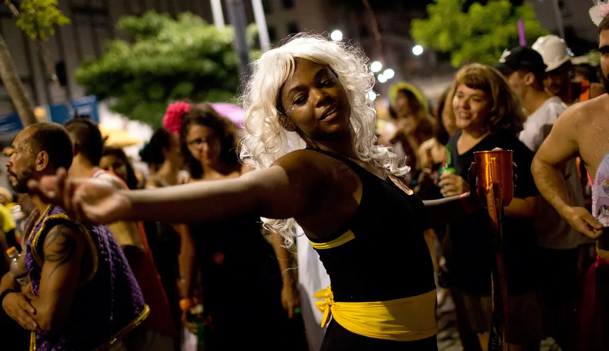 Seorang wanita menari saat merayakan karnaval "Maria vem com as outras" di Rio de Janeiro, Brasil (3/2). Karnaval ini digelar agar mendorong wanita di Brasil melaporkan pelecehan jika terjadi pada mereka. (AP Photo / Silvia Izquierdo)