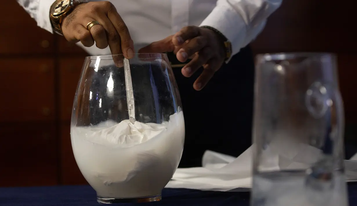 Insinyur Chile, Roberto Astete melarutkan tas plastik bermaterial biodegradable ke dalam air pada konferensi pers di Santiago, Selasa (24/7). Tas inovatif itu bisa menjadi pengganti plastik-plastik yang selama ini mencemari lingkungan. (AFP/CLAUDIO REYES)
