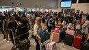 Calon penumpang melakukan lapor masuk di Bandara Internasional Juanda Surabaya di Sidoarjo, Jawa Timur, Sabtu 6 April 2024. (JUNI KRISWANTO/AFP)