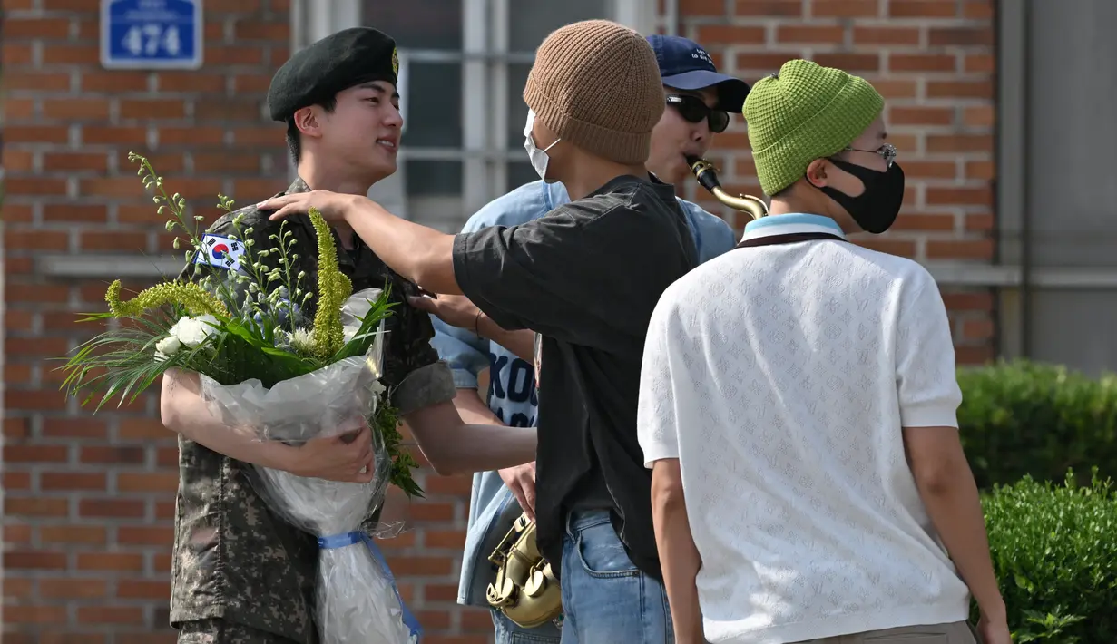 Tak lama kemudian, anggota BTS lainnya, termasuk J-Hope, V, dan Jungkook, juga muncul untuk menyambut Jin. (Jung Yeon-je / AFP)