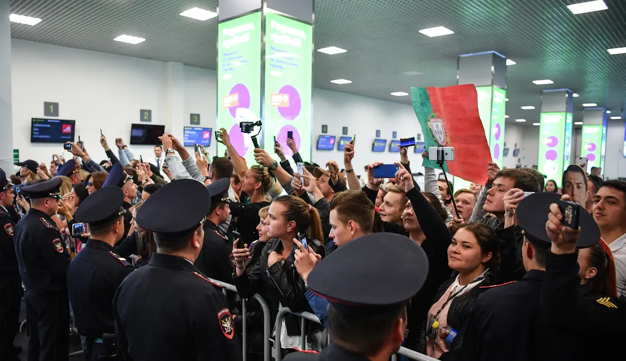 Suporter menyambut kedatangan timnas Portugal saat tiba di Bandara Zhukovsky, Moskow, Sabtu (9/6/2018). CR 7 akan berjuang bersama Portugal pada ajang Piala Dunia 2018 Rusia. (AFP/Yuri Kadobnov)