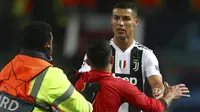 Fans Manchester United menerobos lapangan saat melawan Juventus pada laga Liga Champions di Stadion Old Trafford, Selasa (24/10/2018). Aksi nekat fans tersebut untuk bersalaman dan berfoto dengan Cristiano Ronaldo. (AP/Dave Thompson)