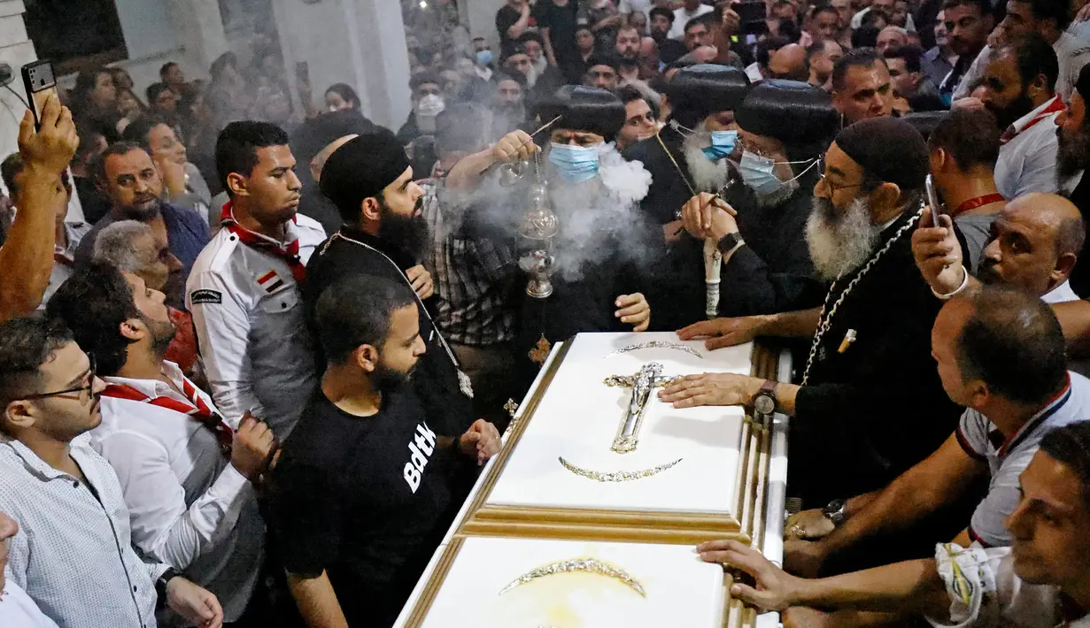 Suasana pemakaman korban tewas dalam kebakaran gereja kristen koptik di Gereja Santa Perawan Maria, Kairo, Provinsi Giza, Mesir, 14 Agustus 2022. Presiden Mesir Abdel Fattah El Sisi berkata peristiwa kebakaran itu adalah "kecelakaan tragis" dan meminta lembaga-lembaga terkait untuk mengurusnya, serta memberikan perawatan kepada korban luka. (Khaled DESOUKI/AFP)