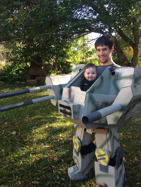 Bocah bernama Geraint tampak tersenyum saat ia bersama ayahnya memakai kostum Halloween yang diberi judul MechWarrior Halloween (Imgur.com)