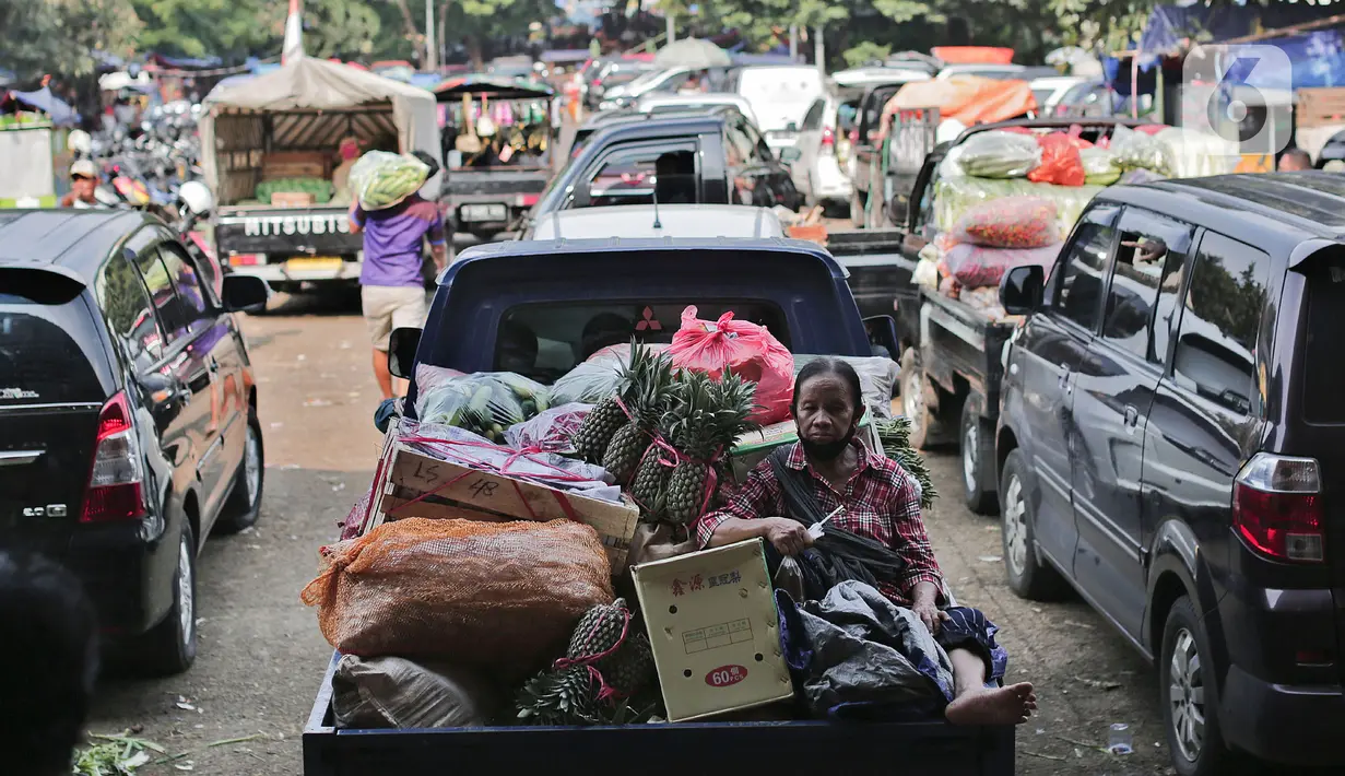 Aktivitas bongkar muat sayur dan buah-buahan di Pasar Induk Kramat Jati, Jakarta Timur, Minggu (12/4/2020). Kegiatan di pasar tersebut berjalan normal selama pandemi COVID-19, namun penjual dan pekerja masih terlihat belum mengenakan masker. (Liputan6.com/Johan Tallo)