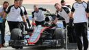Tim Mekanik McLaren sedang mempersiapkan mobil Jenson Button untuk mengikuti latihan bebas pertama di Sirkuit Internasional Bahrain, Jumat (17/4/2015). (AP Photo/Kamran Jebreili)