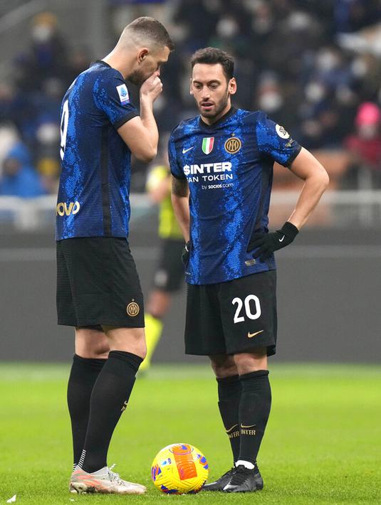 Pemain Inter Milan Edin Dzeko (kiri) dan Hakan Calhanoglu berbicara saat melawan Venezia pada pertandingan sepak bola Liga Italia di Stadion San Siro, Milan, Italia, 22 Januari 2022. Inter Milan menang 2-1. (AP Photo/Luca Bruno)