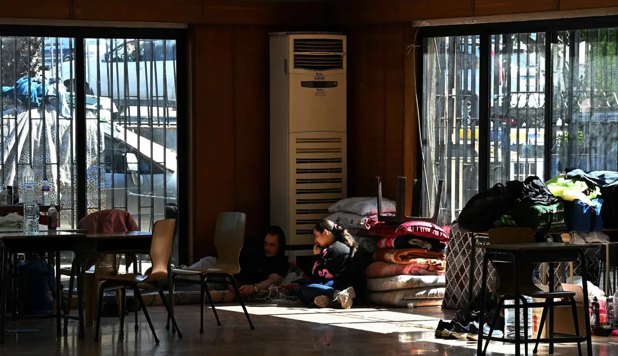Meningkatnya serangan Israel di Lebanon membuat warga mulai meninggalkan rumah dan menempati sekolah-sekolah yang diubah menjadi tempat penampungan di kota Dekwaneh, utara Beirut. Tampak dalam foto, orang-orang duduk di dalam sebuah sekolah yang diubah menjadi tempat penampungan bagi para pengungsi di kota Dekwaneh, utara Beirut, Lebanon, pada Kamis 5 Maret 2026. (Joseph EID/AFP)