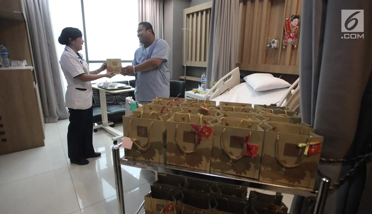 Dokter RS Siloam memberikan jeruk kepada pasien di RS Siloam, Semanggi, Jakarta, Kamis (15/2). MRCCC Siloam Hospitals Semanggi membagikan jeruk kepada pasien rawat inap dalam rangka Imlek. (Liputan6.com/Arya Manggala)