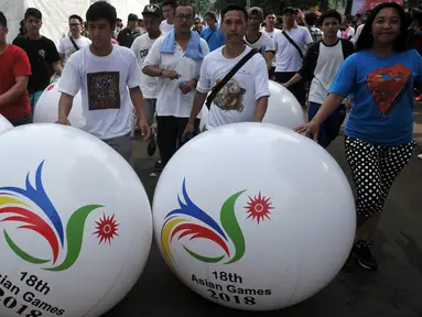 Peserta parade membawa balon bergambar Logo Asean Games 2018 Jakarta-Palembang saat peluncuran logo Asian Games 2018, Jakarta, Minggu (27/12/2015). Indonesia akan menjadi tuan rumah perhelatan Asian Games 2018 mendatang. (Liputan6.com/Johan Tallo)