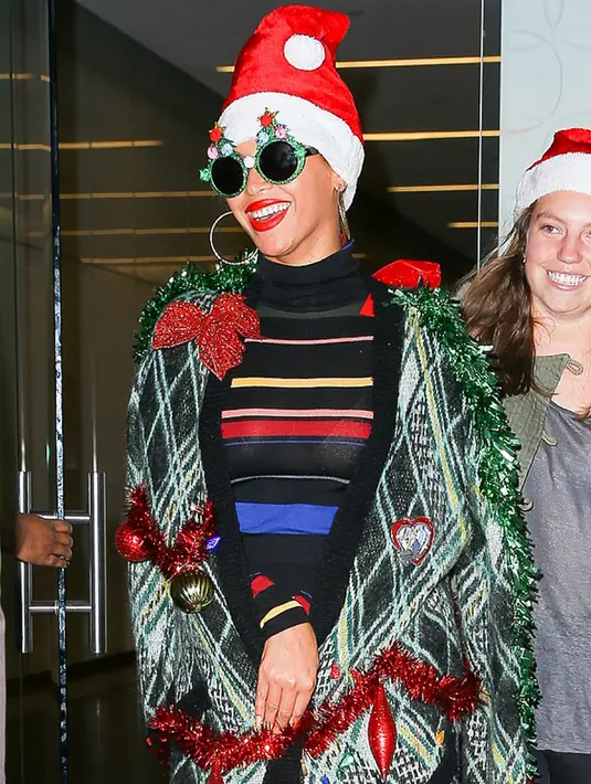 Penyanyi Beyonce tampil dalam balutan dress hitam turtle neck bergaris dipadu dengan cardigan panjang abu-abu yang dihiasi berbagai dekorasi Natal di New York City, Senin (14/12/2015) malam. (dailymail.co.uk)