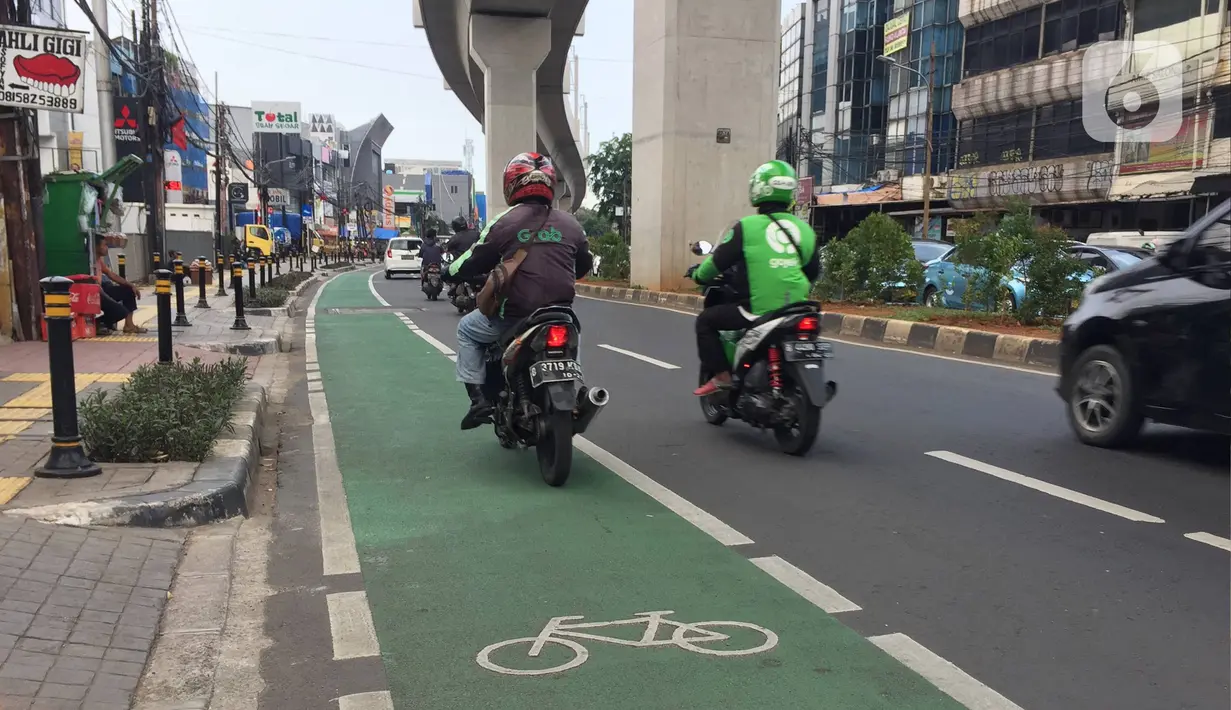 Pengendara sepeda motor melintasi jalur khusus sepeda di Jalan Fatmawati Raya, Jakarta, Rabu (22/1/2020). Kurangnya penerapan sanksi menyebabkan jalur khusus bagi pesepeda tersebut tidak steril dari kendaraan bermotor. (Liputan6.com/Immanuel Antonius)