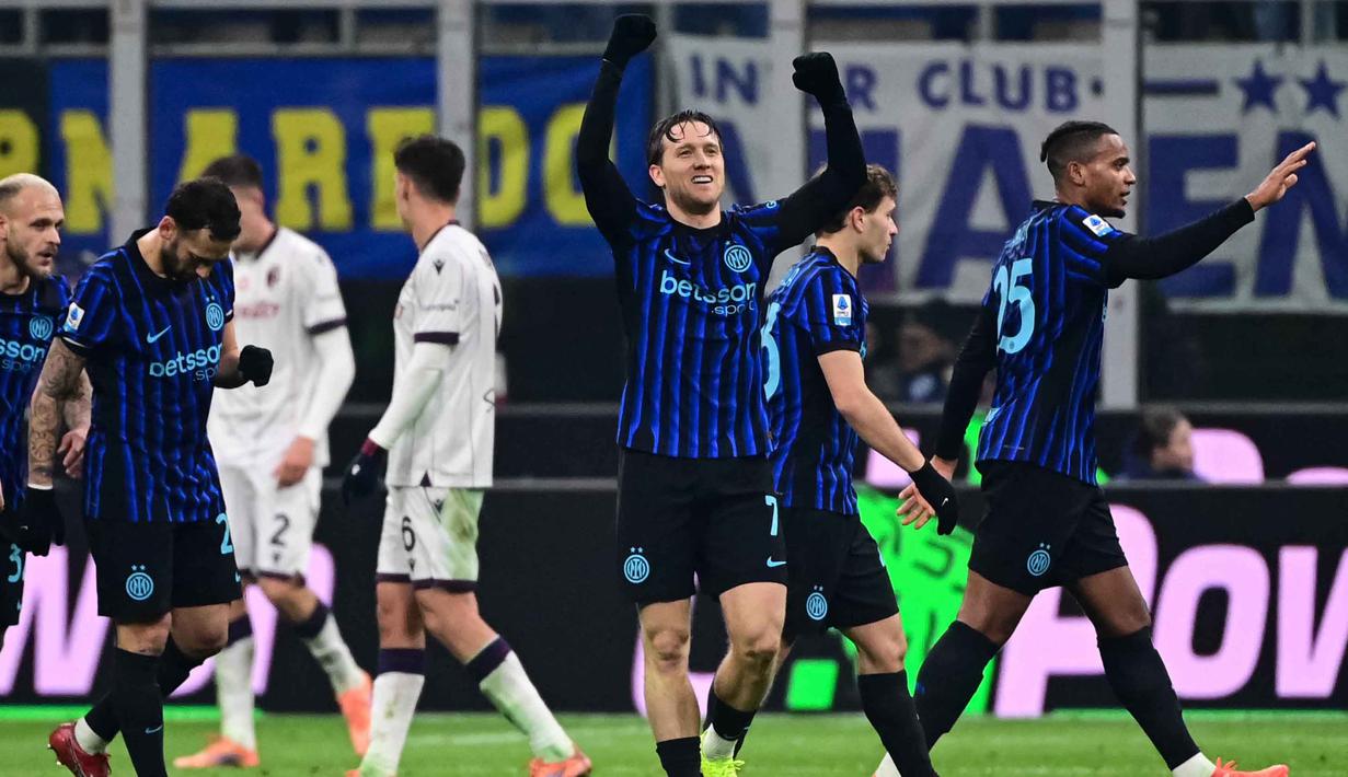 Gelandang Inter Milan asal Polandia, Piotr Zielinski (tengah) merayakan golnya dalam pertandingan pekan ke-17 Serie A Italia melawan Bologna di Stadion San Siro, Milan, Minggu (4/1/2026) waktu setempat atau Senin (5/1/2026) dini hari WIB. Inter Milan memastikan kembali ke puncak klasemen usai meraup poin penuh pada pertandingan pekan ke-18 Serie A Italia 2025/2026. (Piero CRUCIATTI/AFP)