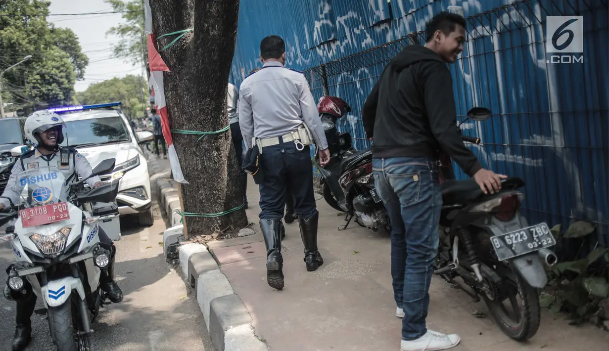 Petugas Dishub DKI Jakarta saat merazia kendaraan roda dua ang terparkir di trotoar di kawasan Cipete Raya, Jakarta, Selasa (13/8/2019). Razia tersebut dilakukan Dishub untuk mengembalikan fungsi trotoar untuk pejalan kaki. (Liputan6.com/Faizal Fanani)