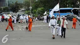 Petugas kebersihan DKI Jakarta mulai beraksi usai demontrasi mendesak mundur Gubernur DKI Jakarta, Basuki Tjahaja Purnama, Jakarta, Jumat (14/10).  (Liputan6.com/Helmi Fithriansyah)
