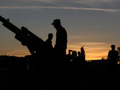 Tentara Yordania menyiapkan meriam penanda waktu berbuka puasa di Benteng Amman pada 19 Mei 2019.  Di Yordania dan beberapa negara timur tengah, tembakan meriam saat matahari terbenam menandai akhir dari puasa selama bulan suci Ramadan. (REUTERS/Muhammad Hamed)