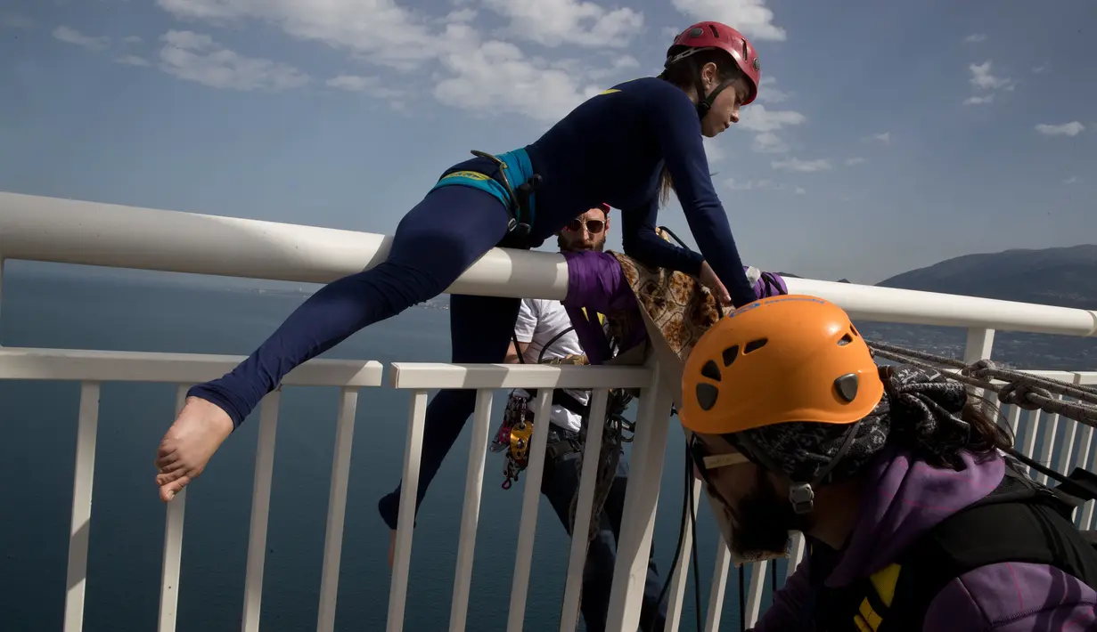 Seorang koreografer dan penari "ekstrem", Katerina Soldatou kembali menaiki jembatan Rio-Antirio setelah melakukan tarian di Yunani selatan, Senin (12/3).  Jembatan ini merupakan jembatan bentang kabel terpanjang di dunia. (AP Photo/Petros Giannakouris)