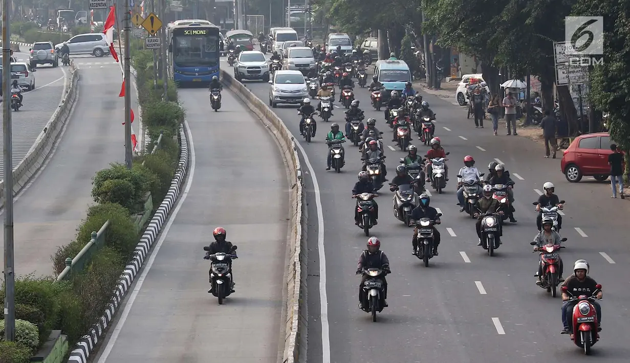 Pengendara sepeda motor melintasi jalur bus Transjakarta di Jalan Otista Raya, Jakarta, Rabu (11/7). Kurangnya pengawasan serta buruknya perilaku pengendara menyebabkan jalur tersebut sering diterobos kendaraan pribadi. (Liputan6.com/Immanuel Antonius)