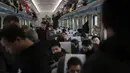 Penumpang menaiki kereta api  menuju kota asal mereka di Beijing, Selasa (29/1). Jutaan orang China telah memulai migrasi manusia terbesar di dunia meninggalkan kota-kota besar menuju kampung halaman untuk merayakan Tahun Baru Imlek. (Nicolas ASFOURI/AFP)