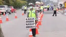 Petugas kepolisian saat melakukan pengecekan SIKM  terhadap kendaran yang akan memasuki  Jakarta di gerbang tol Cikupa, Rabu (27/5/2020). Masyarakat wajib menunjukan SIKM bila ingin kembali atau memasuki Jakarta, Hal tersebut bertujuan untuk menekan penyebaran Covid-19. (Liputan6.com/Angga Yuniar)