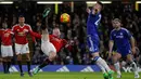  Wayne Rooney (kiri) melakukan tendangan salto saat dihadang pemain Chelsea Gary Cahill pada lanjutan Liga Premier Inggris di Stadion Stamford Bridge, London, Senin (8/2/2016) dini hari WIB.  (AFP/Ian Kington)