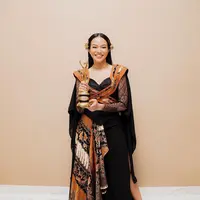 Yura Yunita baru saja menerima penghargaan dengan balutan outfit batik. Outfit ini memiliki siluet edgy yang telah menjadi ciri khas dari gaya Yura Yunita beberapa waktu terakhir. Namun, bisa dilihat di bagian roknya, ada kain batik bernuansa cokelat keemasan yang membaur sempurna dengan dominasi warna hitam pada keseluruhan outfitnya. Foto: Instagram.