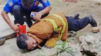 Petugas ketika evakuasi anak ular kobra di lokasi kejadian. (Liputan6.com/Ahmad Adirin)