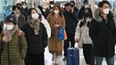 Orang-orang yang memakai masker berjalan di stasiun kereta api Seoul, setelah Korea Selatan mencabut mandat masker dalam ruangan, Senin (30/1/2023). Otoritas Korea Selatan mengimbau pengenaan masker saat berada di dalam ruangan ramai, atau situasi di mana orang-orang berteriak atau bernyanyi. (Jung Yeon-je / AFP)