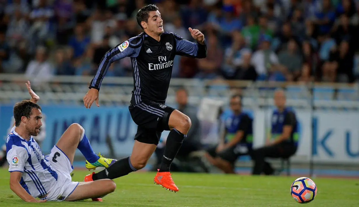Striker Real Madrid, Alvaro Morata, berhasil melewati penjagaan pemain Real Sociedad, Mikel Gonzalez. Laga ini merupakan debut kembalinya Morata ke La Liga, setelah sebelumnya sempat  bermain bersama Juventus. (Reuters/Vincent West)
