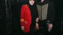 Aurel Hermansyah mengenakan blazer merah dengan aksen list kuning ala pemain drumband. Dipadukan kerudung dan dress hitam. Ibu dua anak ini membawa tas Hermes merah. [@attahalilintar]