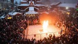 Orang-orang menonton patung Lady Winter yang dibakar saat perayaan Shrovetide di Moskow, Rusia (18/2). Shrovetide atau Maslenitsa adalah hari raya keagamaan dari Slavia Timur. (AP Photo / Pavel Golovkin)