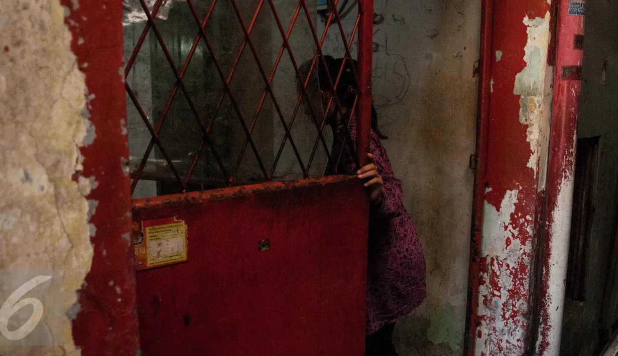 Suasana pintu masuk di rumah yang pernah ditempati oleh Siti Aisyah, di kawasan Tambora, Jakarta Barat, Jumat (17/2). Kini rumah bercat merah dan putih kusam itu masih dijadikan tempat konfeksi oleh pemiliknya yang baru. (Liputan6.com/Gempur M Surya)
