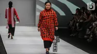 Model disabilitas memperagakan busana rancangan kolaborasi Cotton Ink x Intoart yang digawangi British Council pada Jakarta Fashion Week 2020 di Senayan, Kamis (24/10/2019). Kolaborasi ini menampilkan model disabilitas yang terdiri dari down syndrome, tuna daksa dan tuli. (Liputan.com/Johan Tallo)