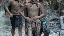 Warga berjalan menyusuri hutan mangrove saat mengikuti tradisi mandi lumpur atau mebuug-buugan di Desa Kedonganan, Denpasar, Bali, Jumat (8/3). Mebuug-buugan diikuti oleh para orang tua, remaja, hingga anak-anak. (Sonny Tumbelaka/AFP)