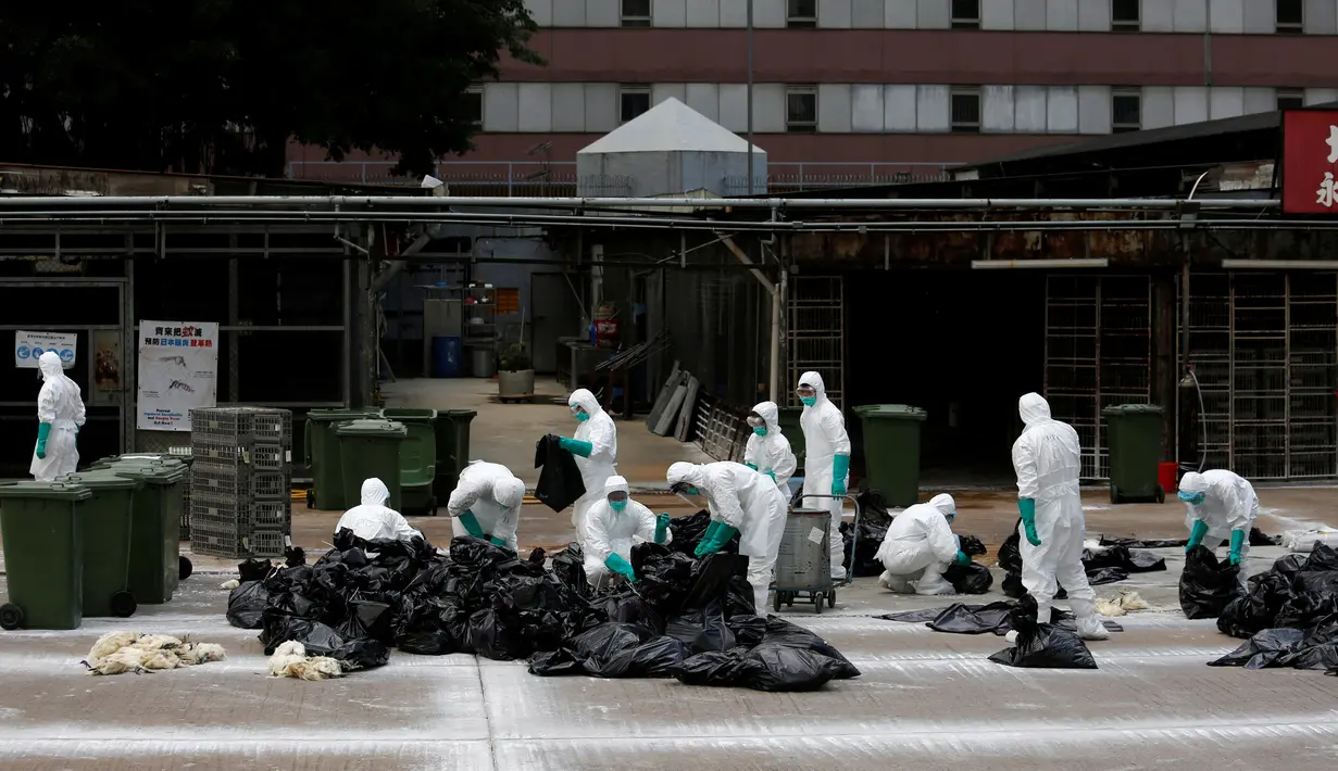Petugas kesehatan menyisihkan unggas ke tempat sampah di sebuah pasar di Hong Kong, (7/6).  Pihak berwenang memutuskan untuk menangguhkan perdagangan unggas hidup setelah pemeriksaan menunjukkan adanya virus flu burung H7N9. (REUTERS/Bobby Yip)