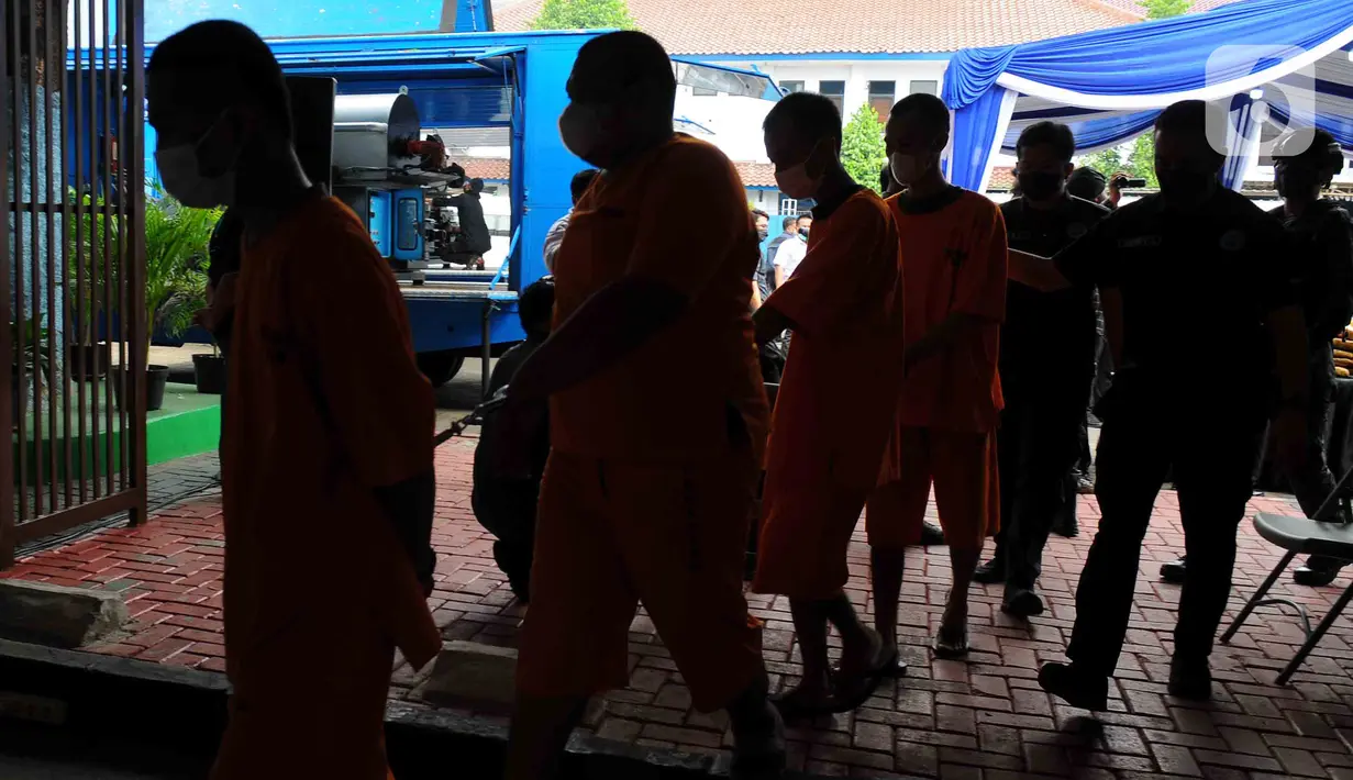 Para tersangka dihadirkan saat pemusnahan barang bukti ganja di Lapangan Gedung BNN, Jakarta, Rabu (18/1/2023). BNN memusnahkan barang bukti 222,697 kilogram ganja dan menangkap empat tersangka berinisial AE alias Adul, RJ, MF, dan G yang merupakan narapidana Lapas Kelas I Tangerang dari pengiriman paket kargo di depan Mall Cijantung. (merdeka.com/Imam Buhori)