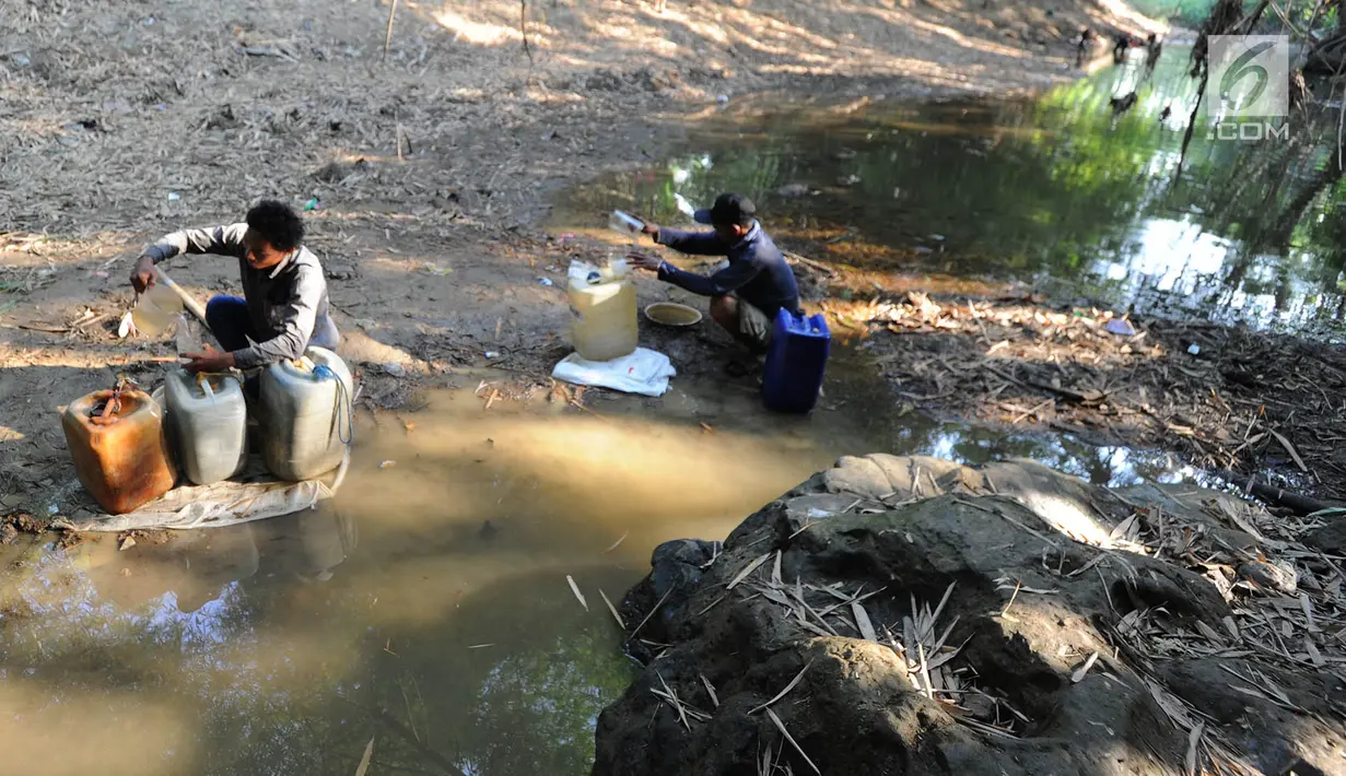 Warga mengambil air dari lubang pada aliran Sungai Cihoe untuk memenuhi kebutuhan sehari-hari termasuk air minum di kawasan Ridogalih, Cibarusah, Bekasi, Minggu (7/7/2019). Sudah lebih dari dua bulan, warga memanfaatkan sisa aliran sungai yang kotor akibat musim kemarau. (merdeka.com/Arie Basuki)