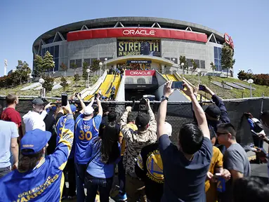 Para suporter mencoba mengambil gambar dari luar Oracle Arena sebelum dimulainya laga final NBA antara Cleveland Cavaliers vs Golden State Warriors. (USA Today/Kelle L Cox)