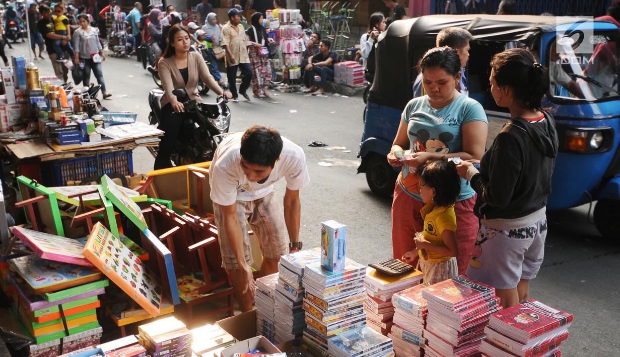 Warga memilih buku tulis ang dijajakan pedagang di sekitar Pasar Asemka, Jakarta, Rabu (5/7). Jelang bergantinya tahun ajaran baru, sejumlah warga berburu peralatan sekolah di kawasan Pasar Asemka Jakarta. (Liputan6.com/Helmi Fithriansyah)