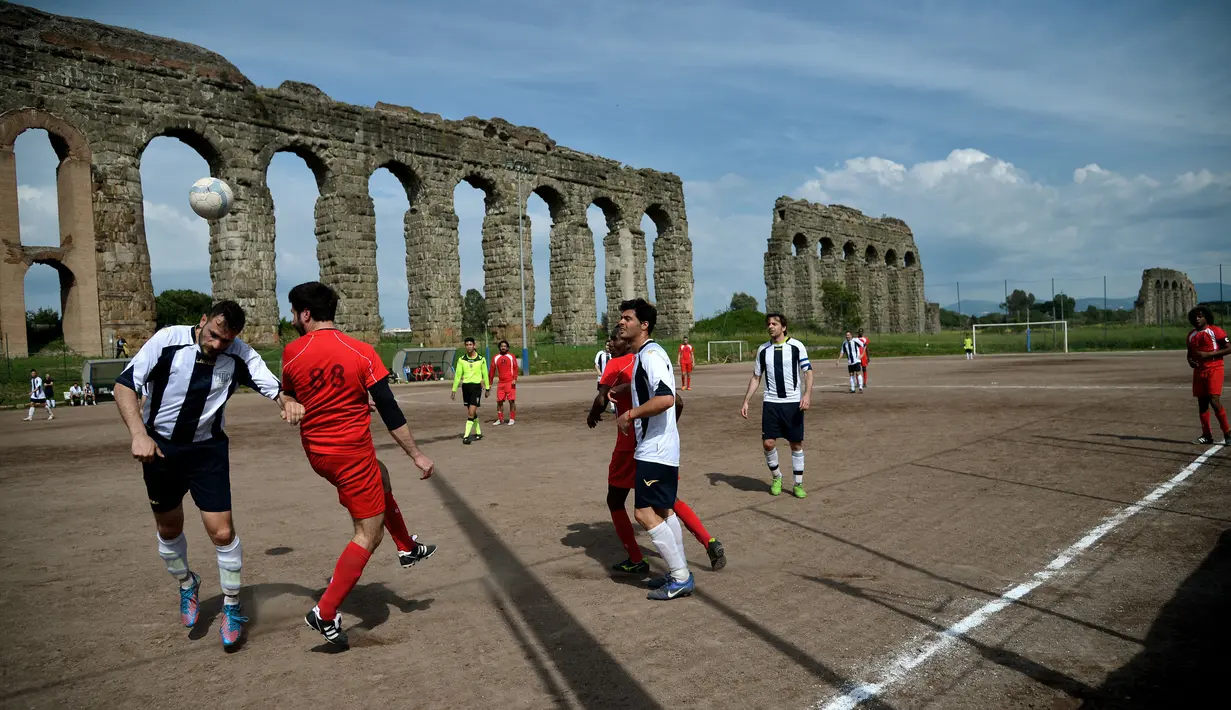 Roma terkenal akan peninggalan bangunan kuno nan megah. Salah satunya adalah Felice Aqueduct di Campo Gerini. Namun tempat yang awalnya dibangun pada tahun 1586 oleh Paus Sixtus V kini berubah menjadi arena olahraga, salah satunya yaitu lapangan sepak bola. (AFP/Filippo Monteforte)